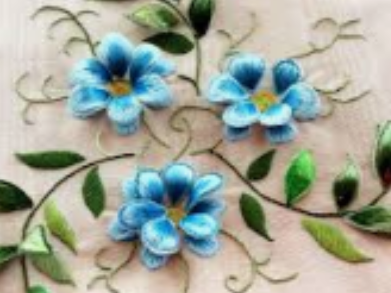 flores azules de cinco pétalos en relieve con tallos y hojas verdes sobre tela blanca