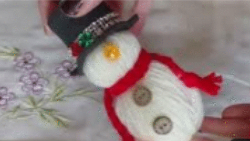 muñeco de nieve con lana con bufanda roja y sombrero de fieltro